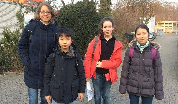 Artur Chan (6e), Nora Hecker (6d) und Arisa Yamada (6c) zusammen mit Frau Kessler nach dem Erfolg beim Kopfrechenwettbewerb